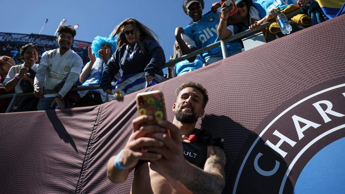 Charlotte FC defender Guzmán Corujo takes selfies with fans after the win against the Atlanta United at the Bank of America Stadium in Charlotte, N.C., on Sunday, April 10, 2022.