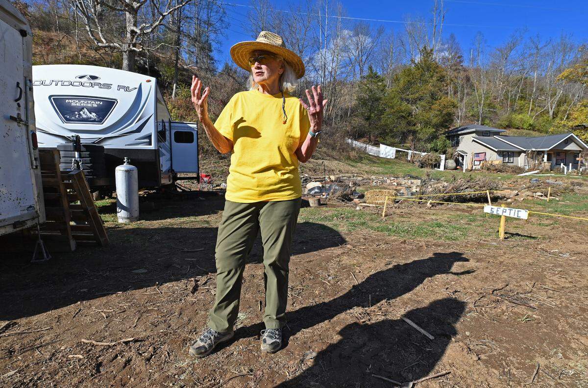 Sharon Hughes of Burnsville discusses how the heavy rain from Hurricane Helene caused the Cane River to overflow its banks flood her home on Monday, Nov. 25, 2024. Hughes’ home was over 100-years-old. She was able to rescue her cats from the flood waters and went to the hill behind her home for safety from the flood water. Hughes is now living in the camper at left.