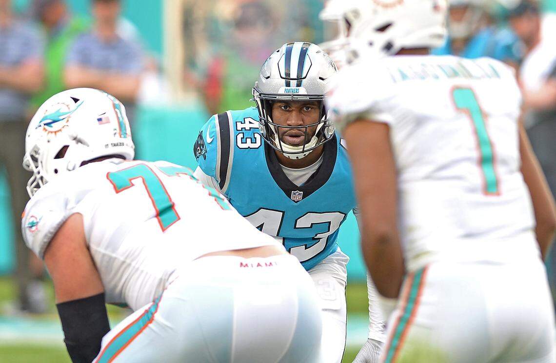 Carolina Panthers linebacker Haason Reddick, center, looks across the line at Miami Dolphins quarterback Tua Tagovailoa, right, during third quarter action at Hard Rock Stadium in Miami Gardens, Fla. on Sunday, November 28, 2021. The Dolphins would defeat the Panthers 33-10.