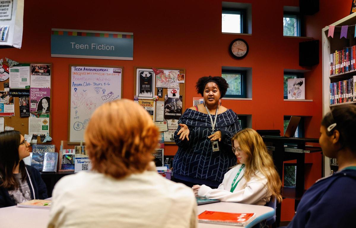 Librarian Alyx Reid, center, speaks to members of Inkspill, a writing group for teens that she started at the Charlotte Mecklenburg Library — University City Regional branch.