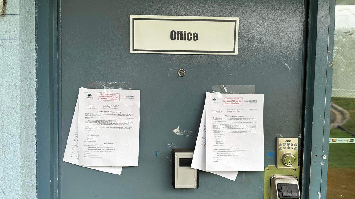 Two complaints and notices of hearing from the city’s code enforcement dated Nov. 7 taped on the office door at the Lamplighter Inn hotel in northwest Charlotte. Each describes issues in two hotel rooms where tenants live.