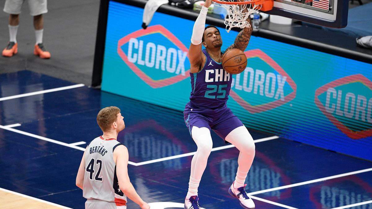 Charlotte Hornets forward P.J. Washington (25) dunks past Washington Wizards forward Davis Bertans (42) during the first half of an NBA basketball game, Sunday, May 16, 2021, in Washington. (AP Photo/Nick Wass)