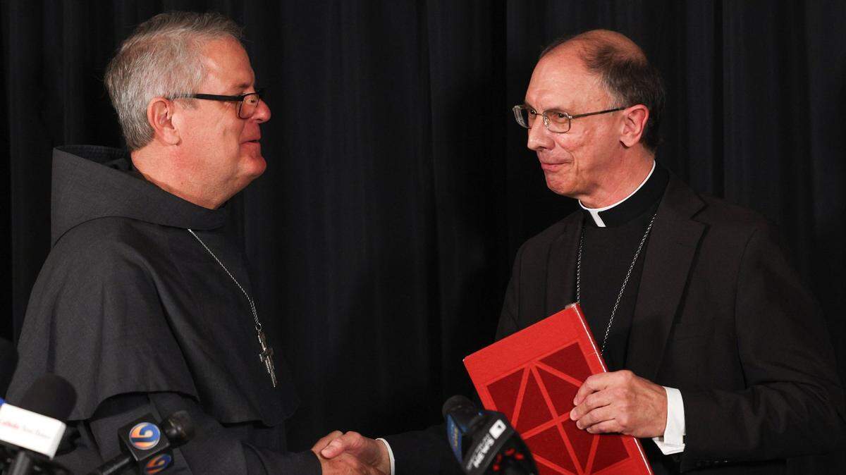 Charlotte Catholic Bishop Peter Jugis, right, shakes hands with Franciscan Father Michael T. Martin, who has been named Jugis’ successor, during a press conference at the Diocese Pastoral Center in Charlotte, NC on Tuesday, April 9, 2024. Jugis, 67, is retiring due to “health limitations,” according to a diocesan statement. Martin will succeed him as the fifth Bishop of Charlotte.