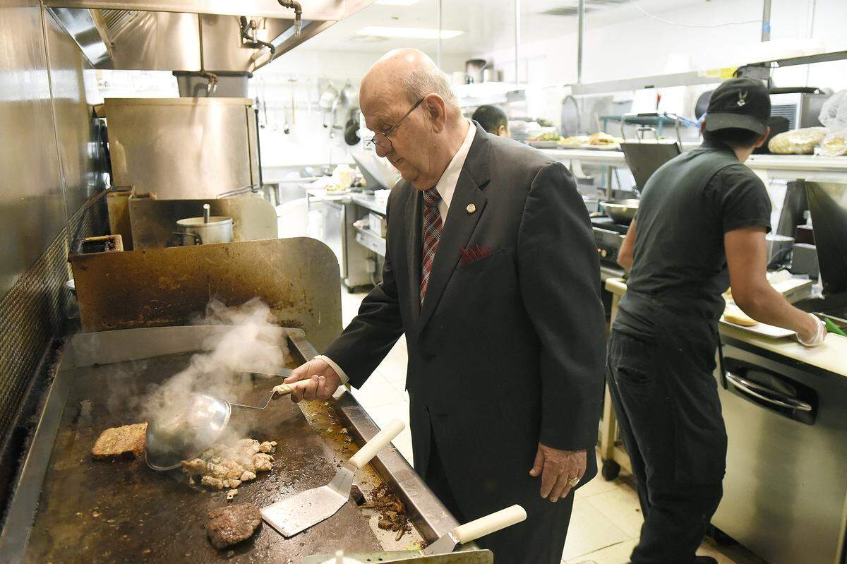 Pete Politis, 87, who opened his first Charlotte restaurant in 1953, checks out food on the flat top grill at the Old Pineville Premium Pub, now co-owned by his grandson Pete Politis, 37.