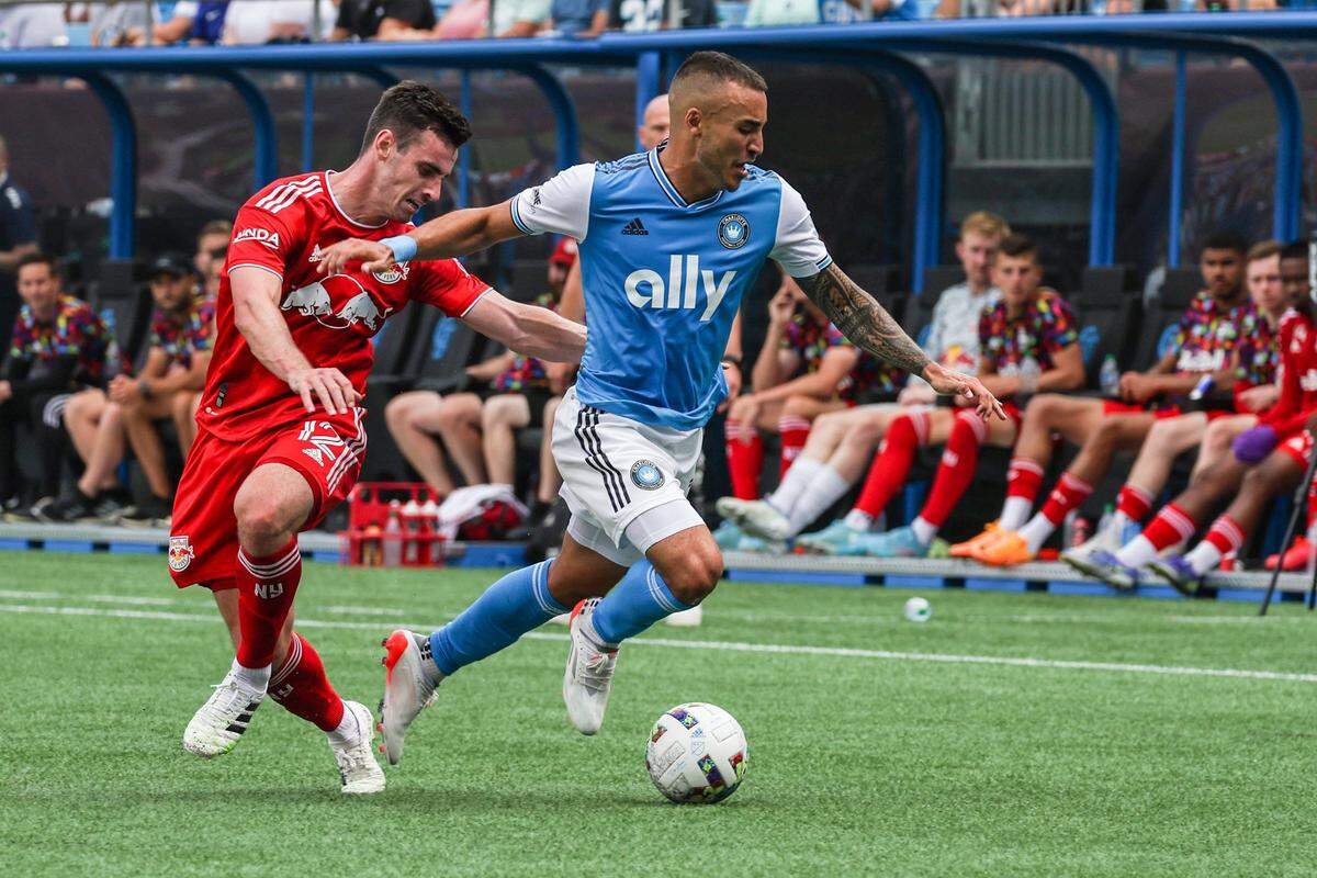 Charlotte FCs Andre Shinyashiki, right, dribbles the ball away from New York Red Bulls Dylan Nealis during the game at Bank of America Stadium on Saturday, June 11, 2022 in Charlotte, NC.