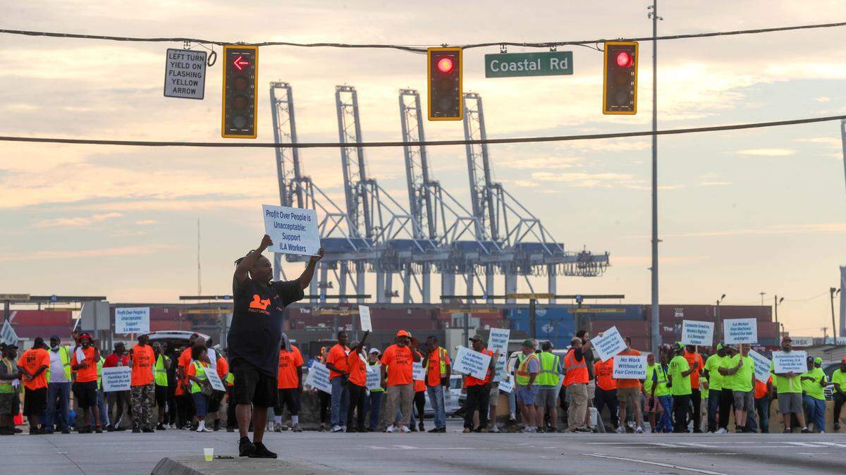 International Longshoremen’s Association member Ramon Robinson holds a picket sign along with fellow union members outside the entrance to the Garden City Terminal on Tuesday as the ILA went on strike at the Georgia Ports Authority in Garden City, Georgia. The Carolinas face supply chain concerns on staple items as a port strike follows damage from Hurricane Helene.