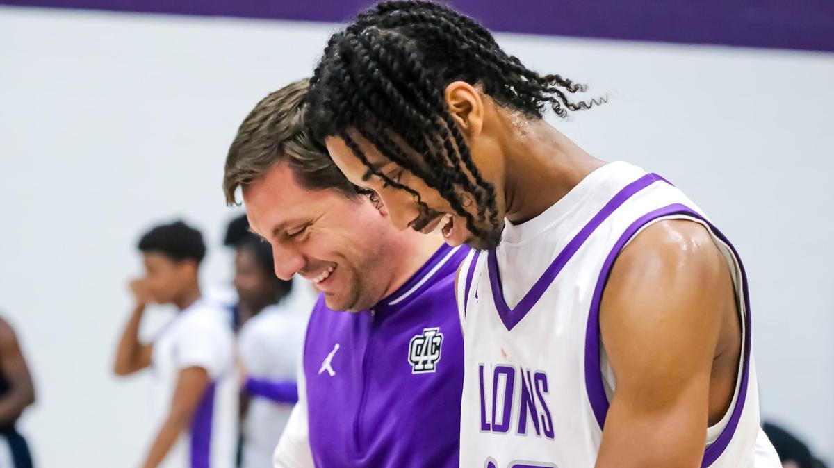 Ambassador Christian head coach Scott Taylor and junior forward Tyler Brown celebrate the Lions’ 62-46 win over Queen’s Grant on Nov. 7, 2024, in Huntersville, N.C.