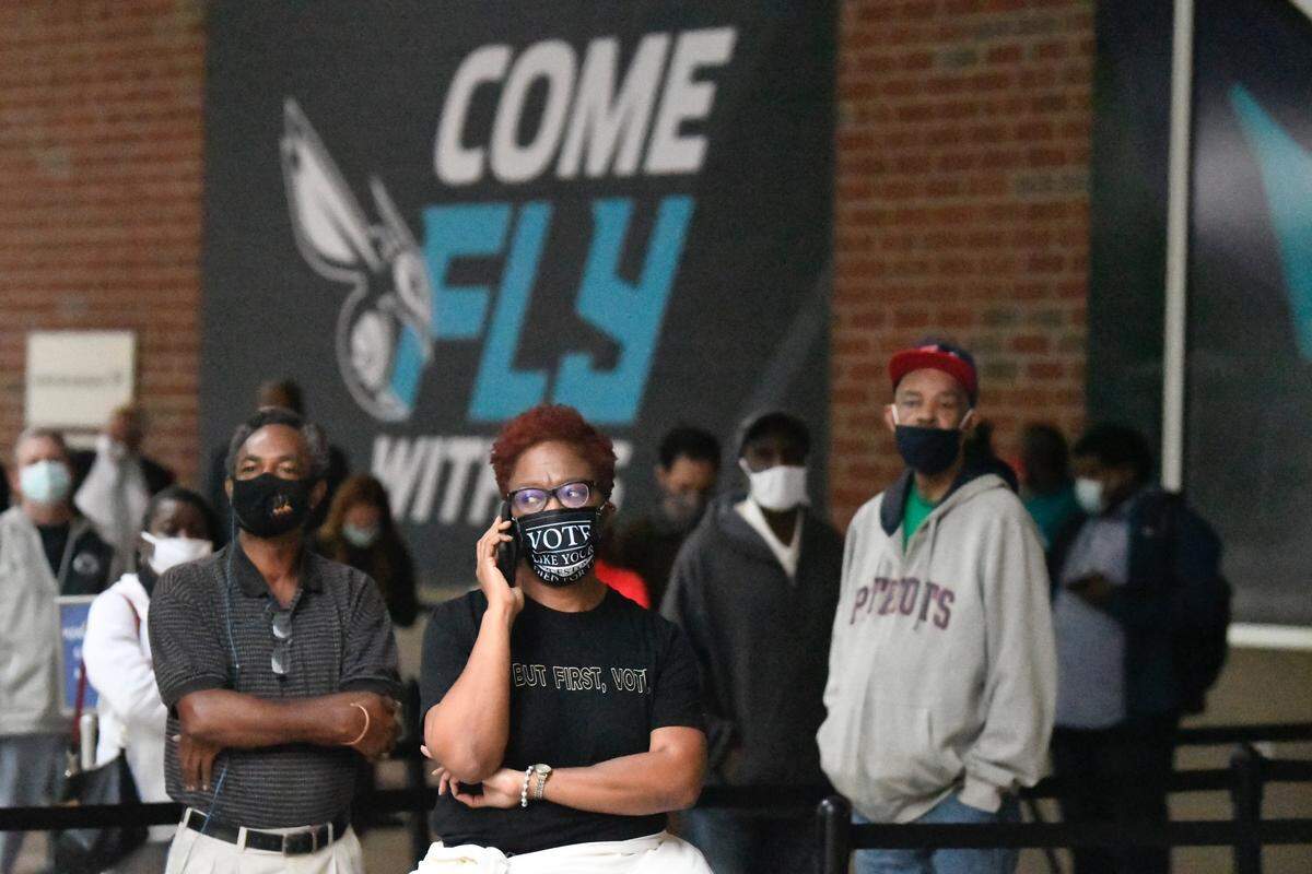 Voters line up in advance of polls opening at the Spectrum Center in Charlotte, N.C. for the first day of early voting Thursday, Oct. 15, 2020.
