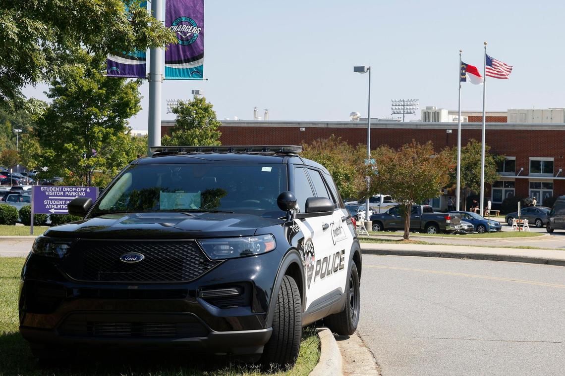 A Concord Police officer sits in their vehicle outside Cox Mill High School following a bomb threat and evacuation in Concord, N.C., Tuesday, Sept. 20, 2022.