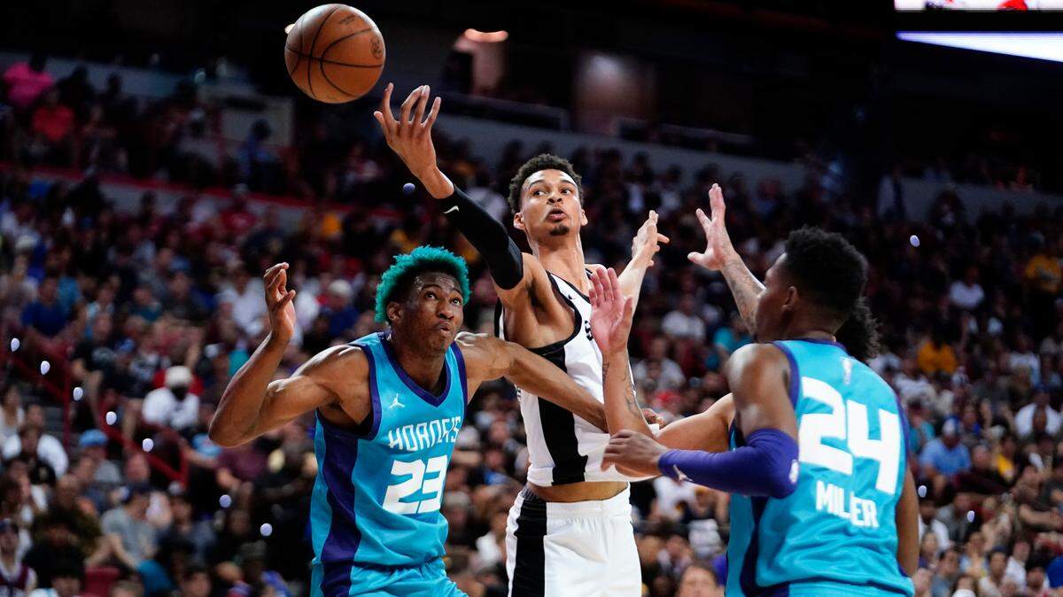 San Antonio Spurs forward Victor Wembanyama (1) reaches for the ball against Charlotte Hornets forward/center Kai Jones (23) and forward Brandon Miller (24) during the second half at Thomas & Mack Center.