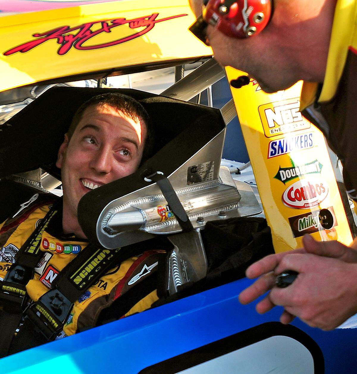 5/20/11 (L-R) NASCAR Sprint Cup Series driver Kyle Busch smiles at a crew member after winning the pole for the Sprint All-Star Race Friday at Charlotte Motor Speedway. The race will be run on Saturday, May 21st. Jeff Siner - jsiner@charlotteobserver.com