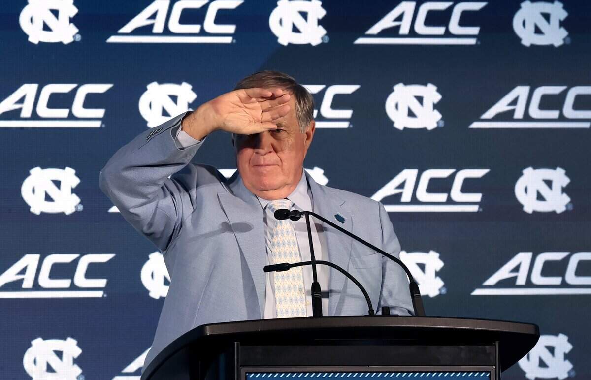 North Carolina head football coach Bill Belichick shields his eyes from the stage lights as he listens to a reporter's question during the 2026 ACC Football Kickoff program at the Charlotte Hilton Uptown hotel on Friday, July 17, 2026.