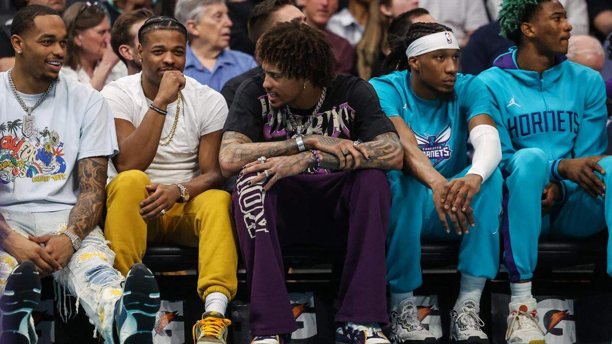 Players, from left, P.J. Washington, Dennis Smith, Jr. and Kelly Oubre, Jr. watch the game from the bench as the Hornets play the Raptors at Spectrum Center on Tuesday, April 4, 2023.