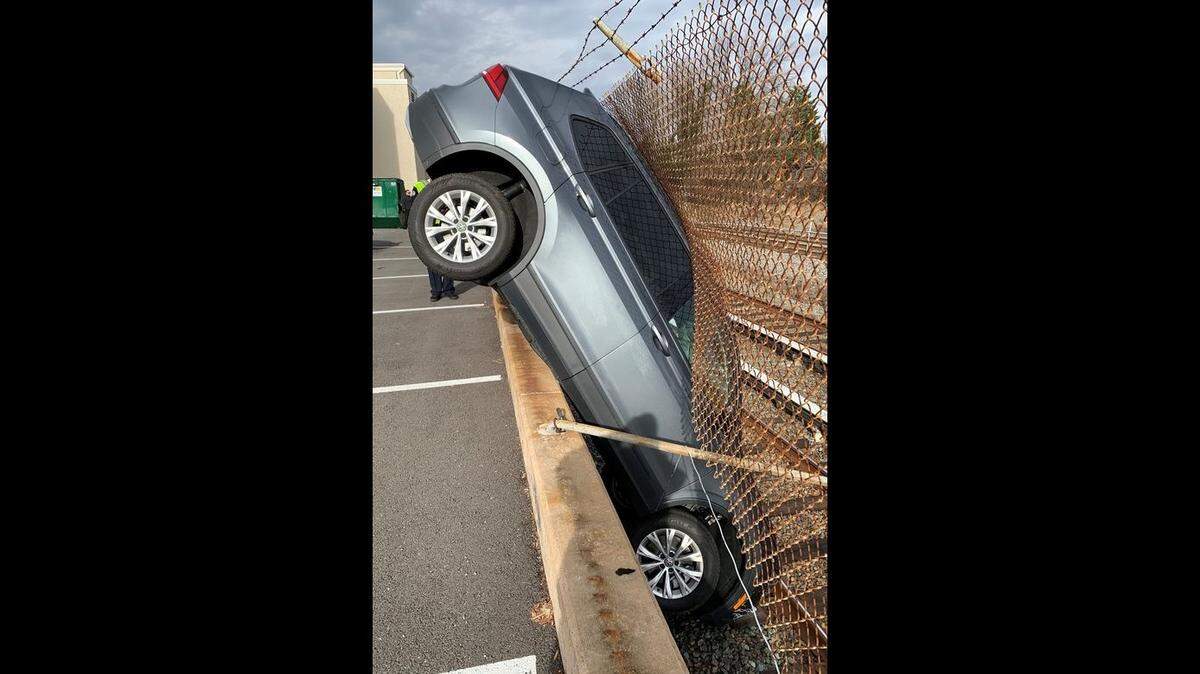 The Rockville City Police Department shared a photo of a car that went through fencing and landed vertical beside train tracks.