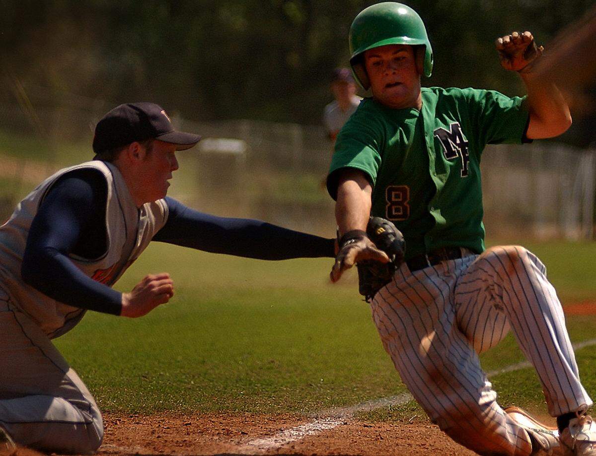 Vance High School pitcher Stephen Leach tags Myers Park Mustang Logan Smith out at the plate in a 2003 game. 