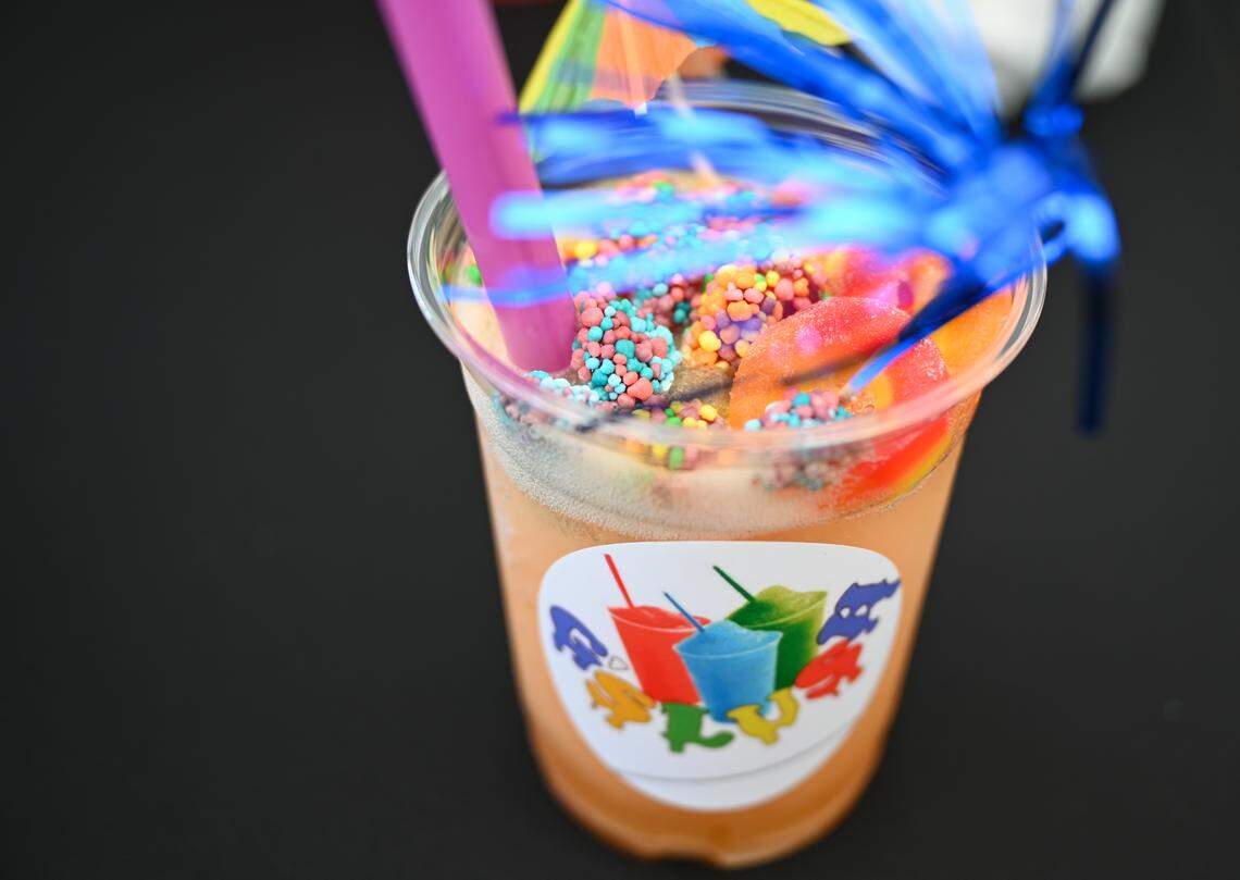 An island vibes slushie from G Slush, made with pineapple, mango and strawberry and topped with Nerds clusters and a peach gummy ring was just one of the many cold beverage offerings from vendors during the West Side Fish Fry at West Complex in Charlotte on Saturday, April 18, 2026.
