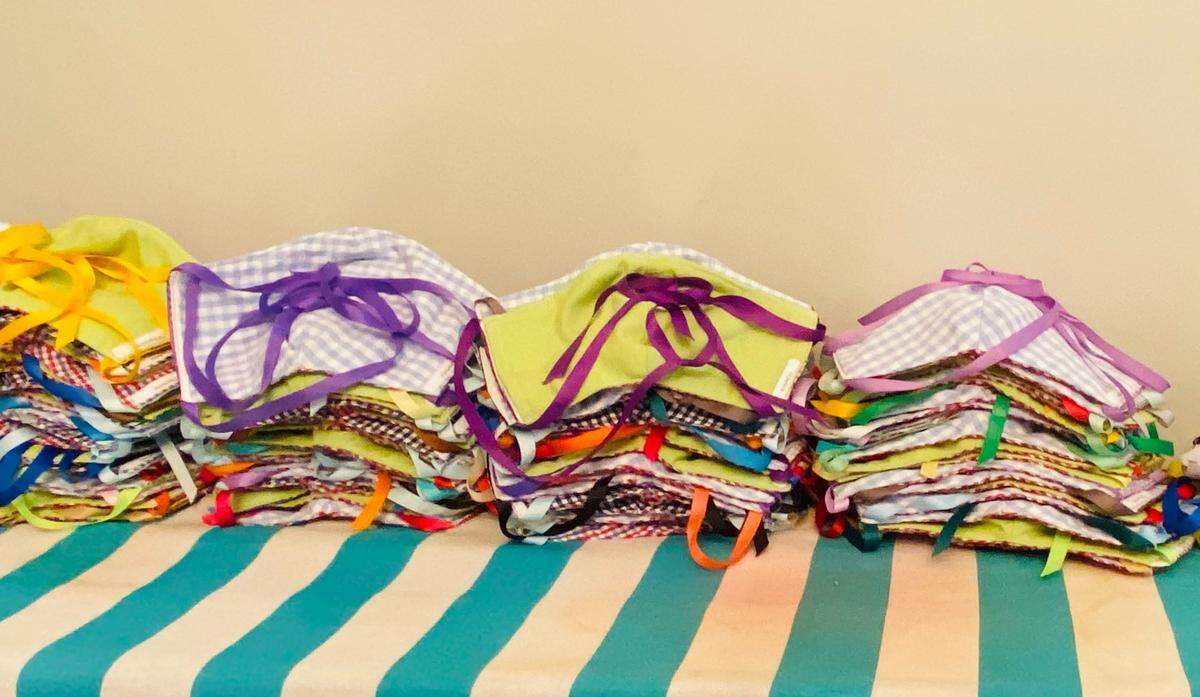 Masks made by Children’s Theatre of Charlotte are stacked on an ironing board. So far, CTC has made 350 masks.