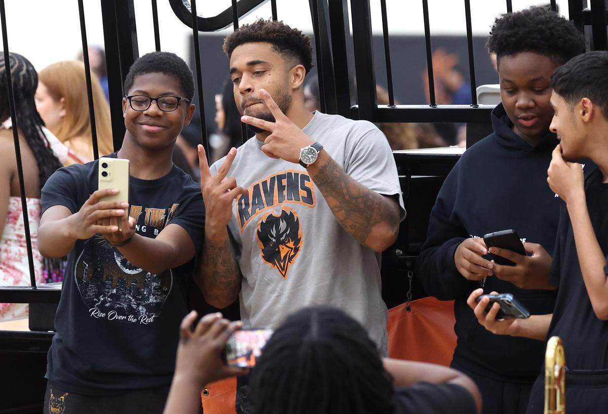NFL defensive back Jaire Alexander, center, poses for photos with members of the Rocky River High School band after his foundation named and presented Rocky River High School student-athlete Nicole Johnson with a scholarship on Tuesday, May 19, 2026.