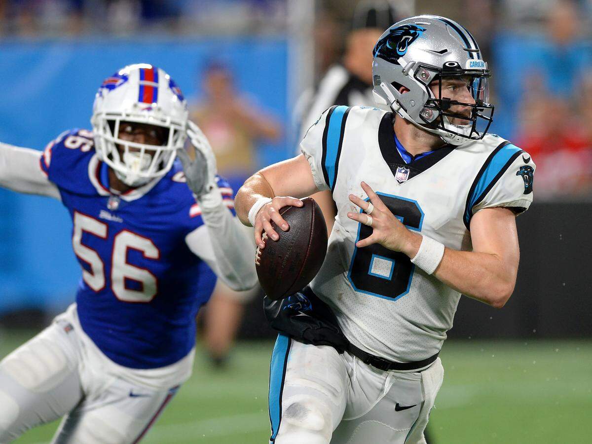 Carolina Panthers quarterback Baker Mayfield rolls out of the pocket as Buffalo Bills defensive end Mike Love, left, gives chase at Bank of America Stadium in Charlotte, NC on Friday, August 26, 2022.
