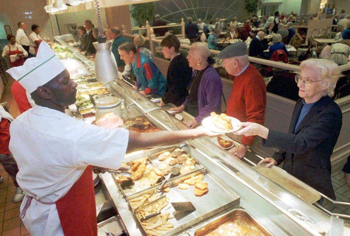 Charles Coleman, left serves up some baked chicken to Sally Porter at Barclay's Cafeteria, a SouthPark landmark, in February 1994.