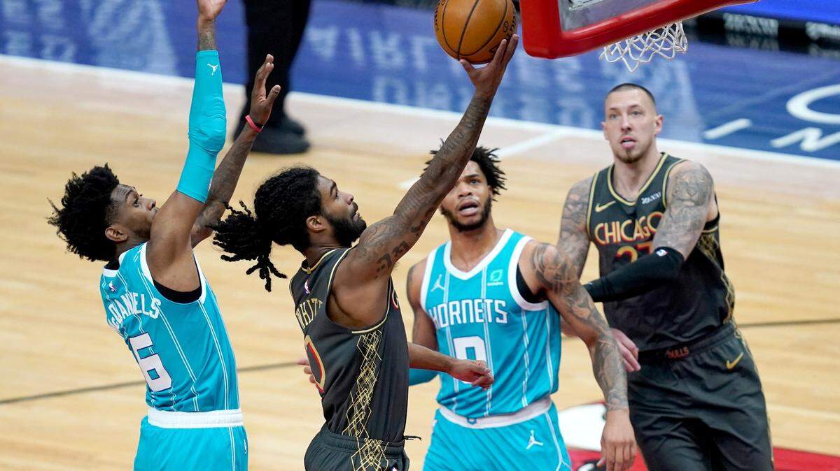 Chicago Bulls’ Coby White, second from left, shoots past Charlotte Hornets’ Jalen McDaniels (6) as Hornets’ Miles Bridges (0) and Bulls’ Daniel Theis, right, watch during the first half of an NBA basketball game Thursday, April 22, 2021, in Chicago. (AP Photo/Charles Rex Arbogast)