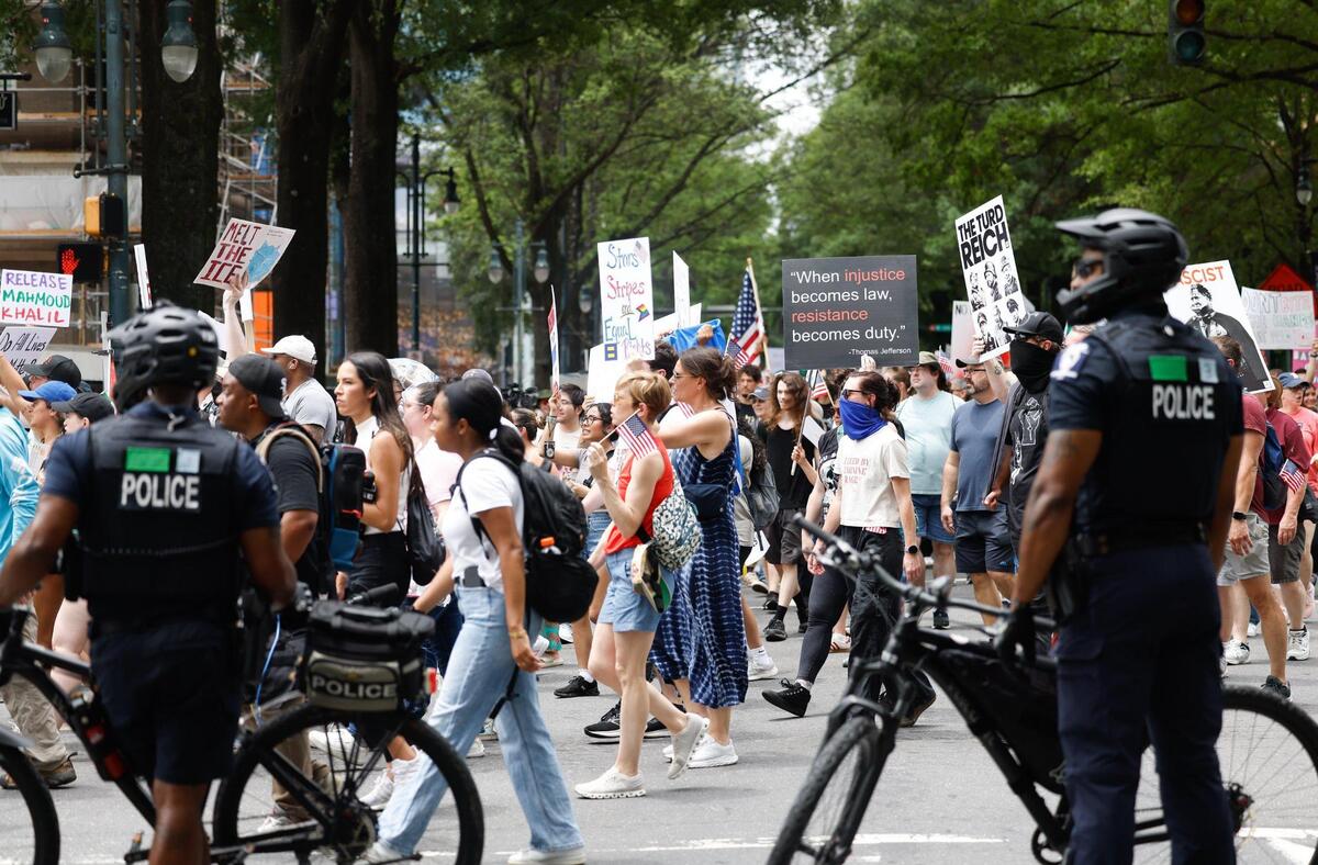 CMPD bike officers block traffic and watch protesters as they participate in the No Kings protest along North Tryon Street and 7th Street in Charlotte Saturday, June 14, 2025.
