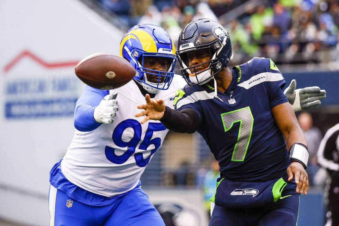 Jan 8, 2023; Seattle, Washington, USA; Seattle Seahawks quarterback Geno Smith (7) passes under pressure from Los Angeles Rams defensive tackle Bobby Brown III (95) during the second quarter at Lumen Field. Mandatory Credit: Joe Nicholson-USA TODAY Sports