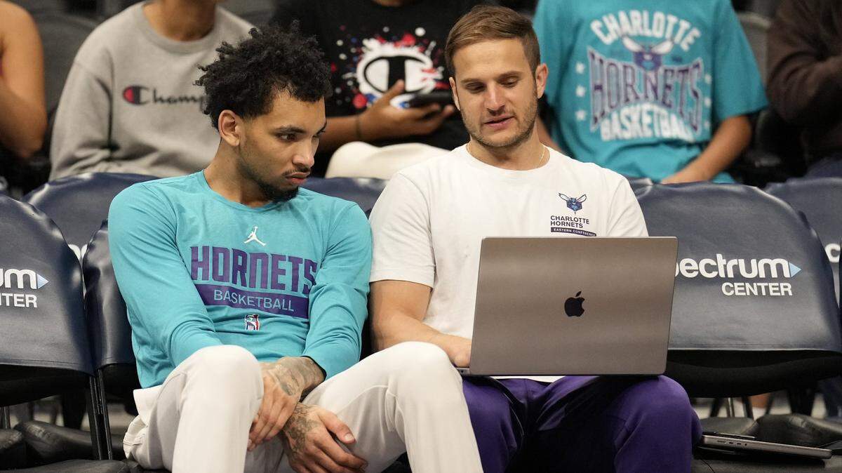 James Bouknight (2) talks with a assiatant coach Nick Friedman during pregame warm ups against the Toronto Raptors at Spectrum Center on April 2.