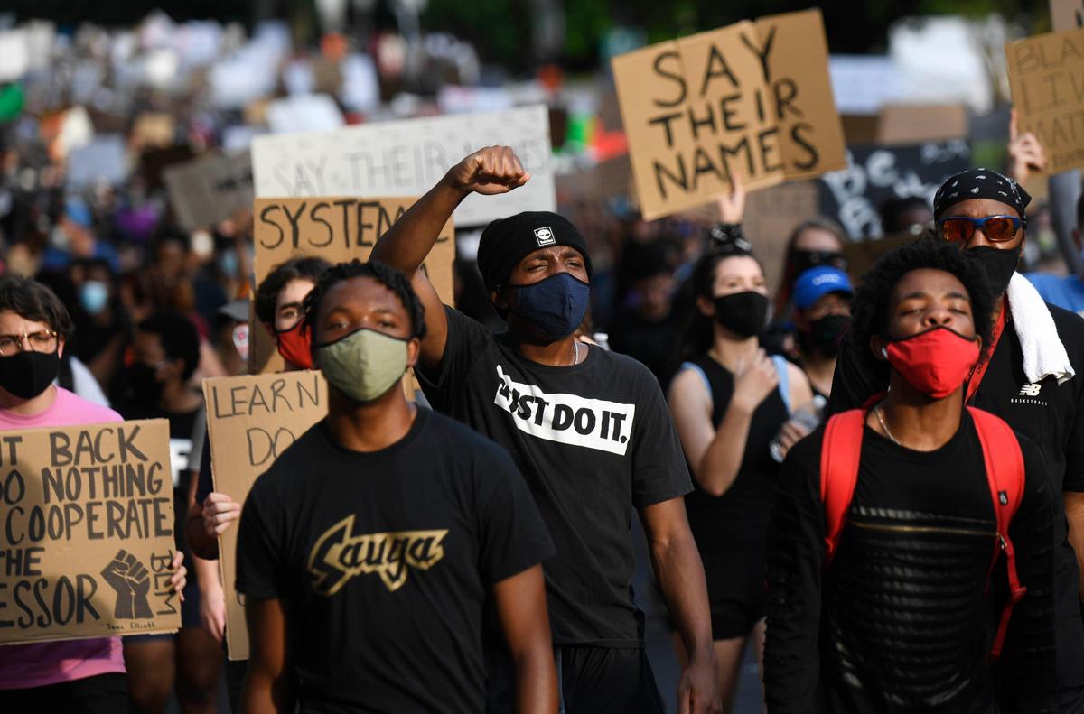 A crowd marches up Third Street past the Charlotte-Mecklenburg Government Center on Monday, June 8, 2020.