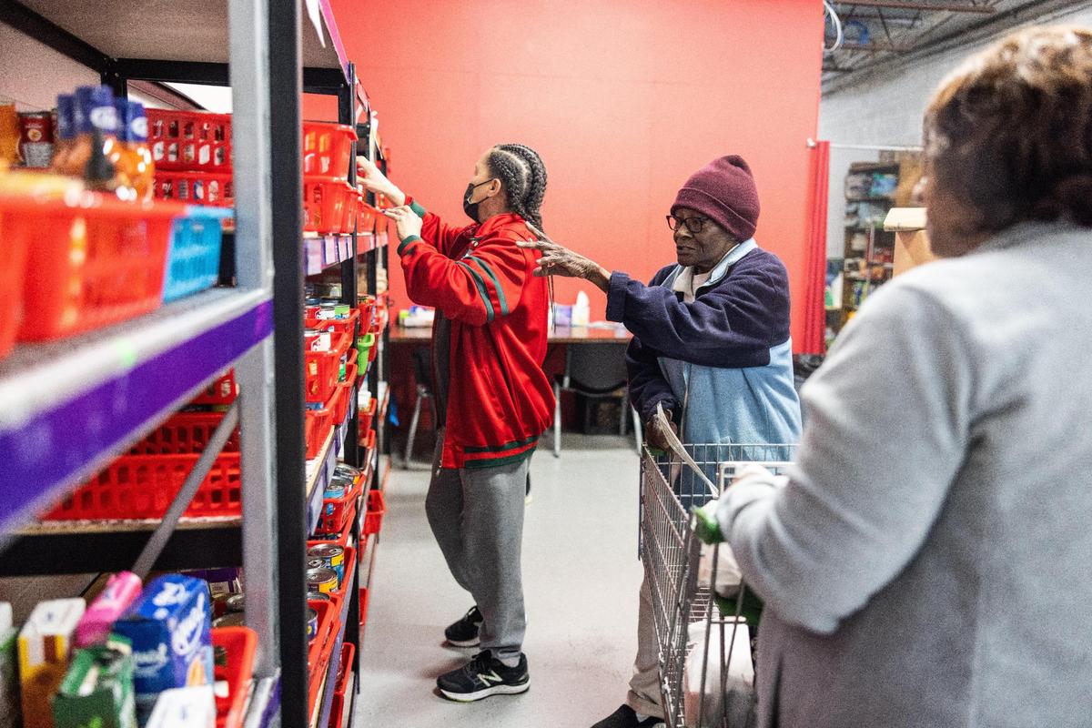 Volunteer Shirley Collins, center, helps a client pick out groceries at Nourish Up’s Mt. Carmel food pantry in Charlotte.