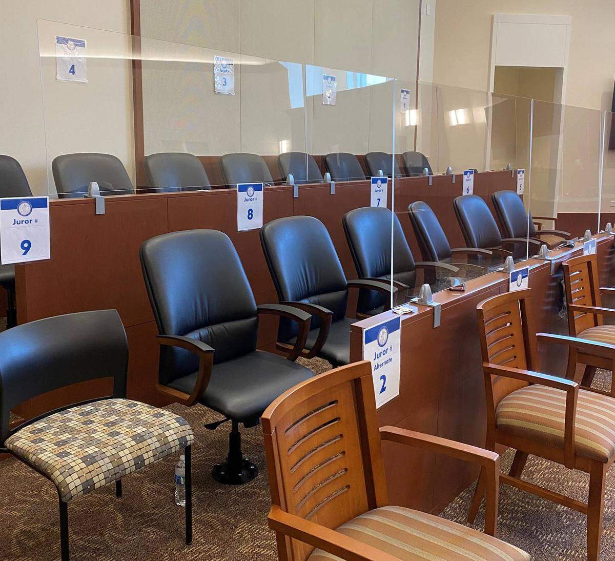 Plexiglass shields surround the jury box in Courtroom 6110 at the Mecklenburg County Courthouse in Charlotte, NC, in August 2021. The signs indicate seating assignments to ensure social distancing.