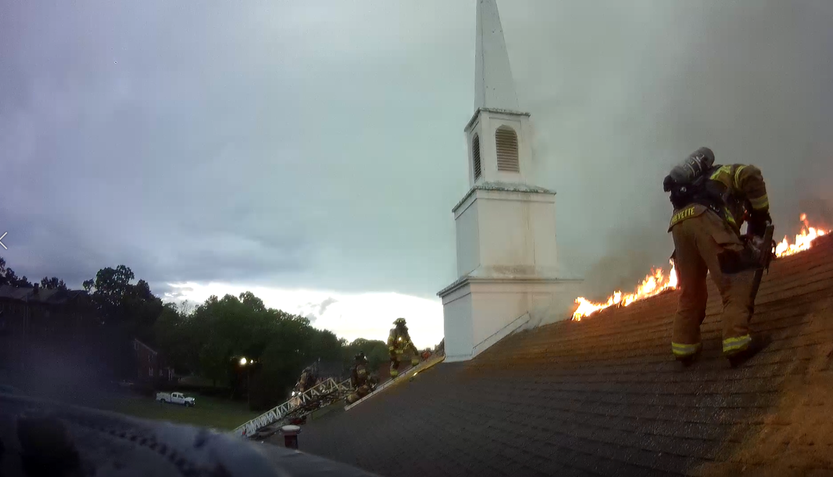 A firefighter tends to a blaze on the roof of Kittie Sanson Chapel on the campus of Barber-Scotia College in Concord, NC, on Thursday, June 17, 2022.