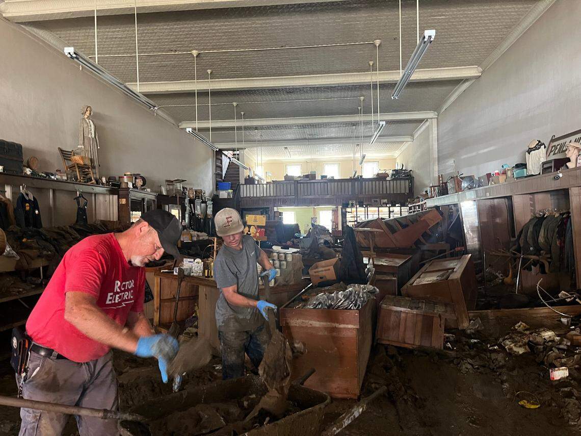 Dennis Rector and his grandson Jackson Massey digging mud out of their family’s general merchandise store in downtown Marshall. The store has been in their family since the 1950s and was among the oldest businesses in town.