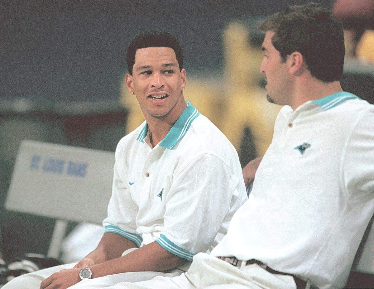 11/14/99 (L-R) Carolina Panther wide receiver Rae Carruth talks with teammate Jason Peter on the bench prior to the team’s game vs the St. Louis Rams at the Trans World Dome in St. Louis, MO. Carruth was arrested by Charlotte-Mecklenburg police on Thanksgiving and charged with conspiring to murder Cherica Adams who was pregnant with his baby. Carruth was charged as Rae Lamar Theotis Wiggins, apparently his real name. He is charged with conspiring to commit first-degree murder, attempted murder and shooting into an occupied vehicle. Also arrested on Thursday was William Edward Watkins Jr., and charged with conspiring to shoot Cherica Adams.