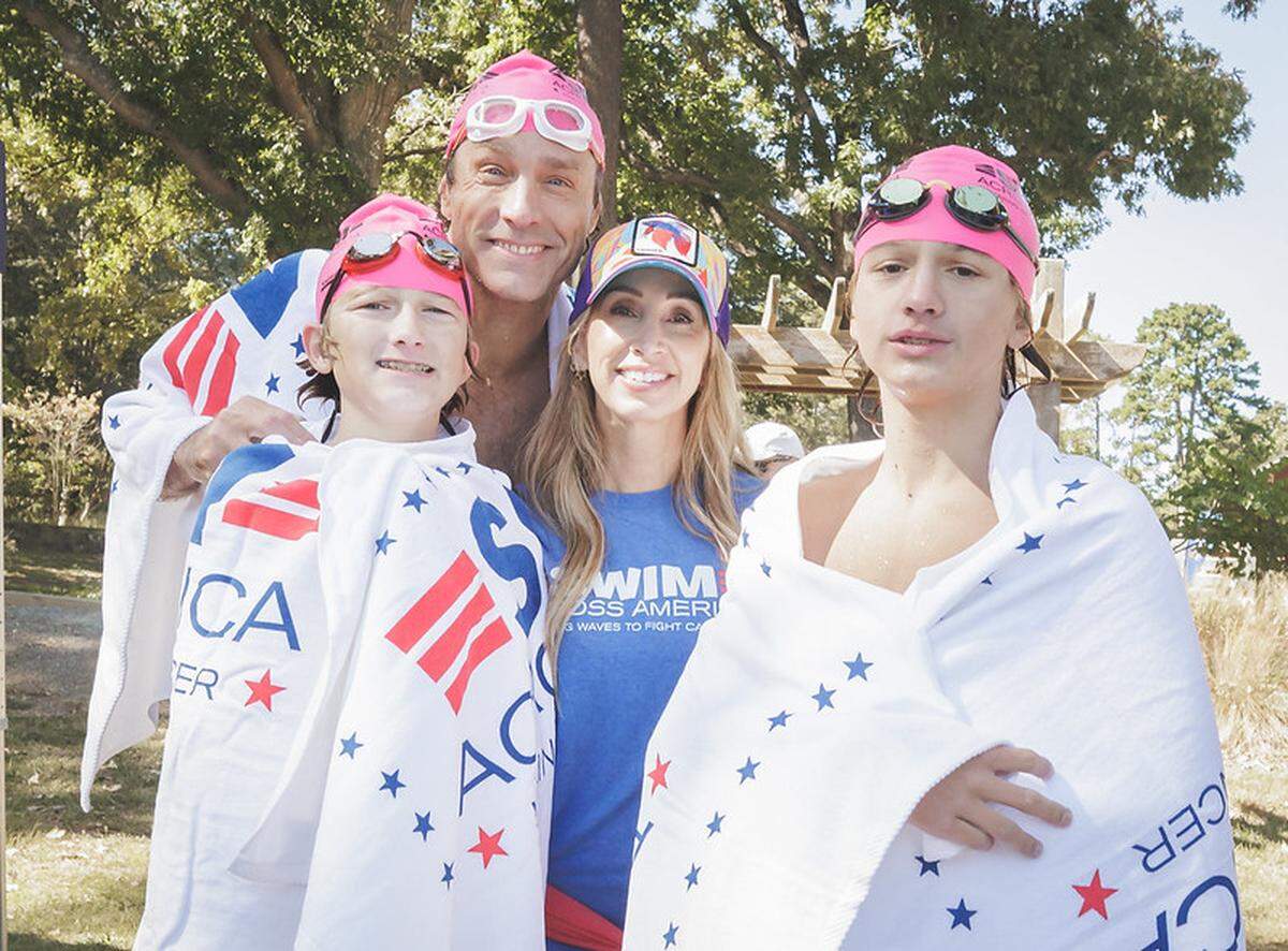 Swim Across America CEO Rob Butcher with his twin sons and his wife at the 2023 charity swim on Lake Wylie.