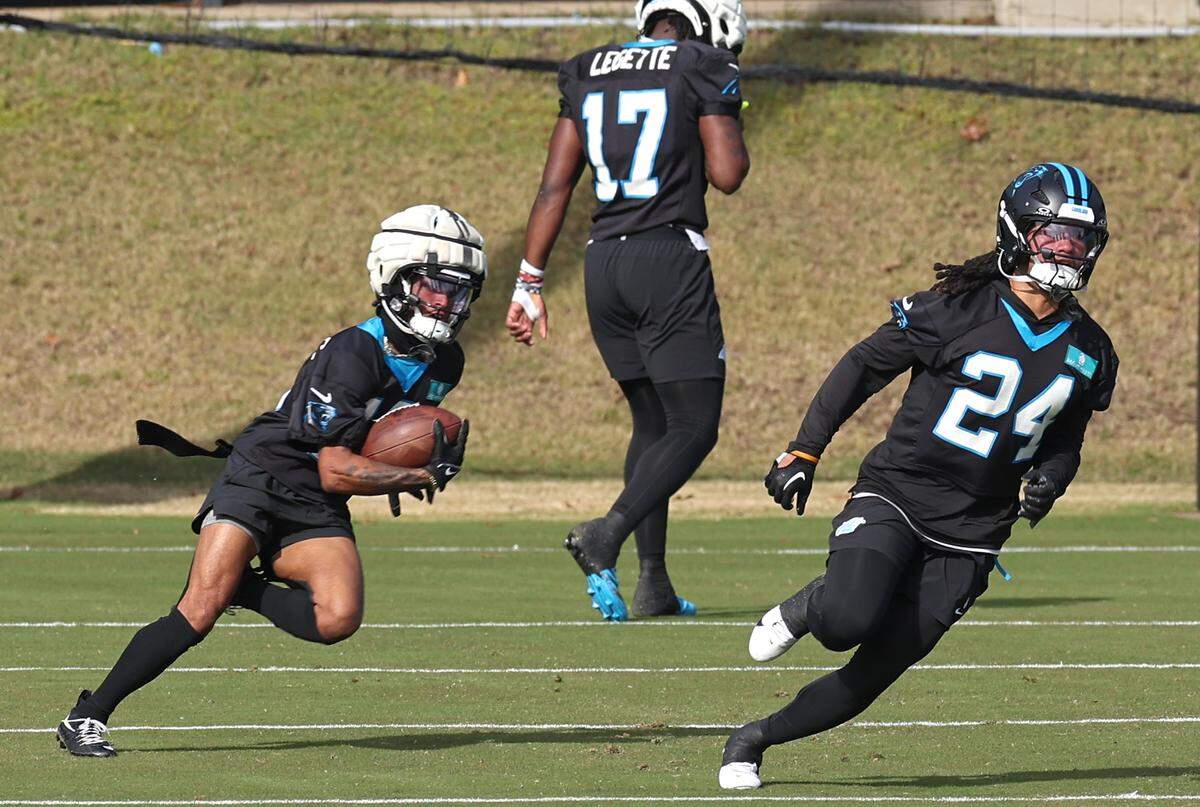 Carolina Panthers rookie running back Jonathon Brooks, right, sprints ahead on a drill during practice on Monday, November 18, 2024.