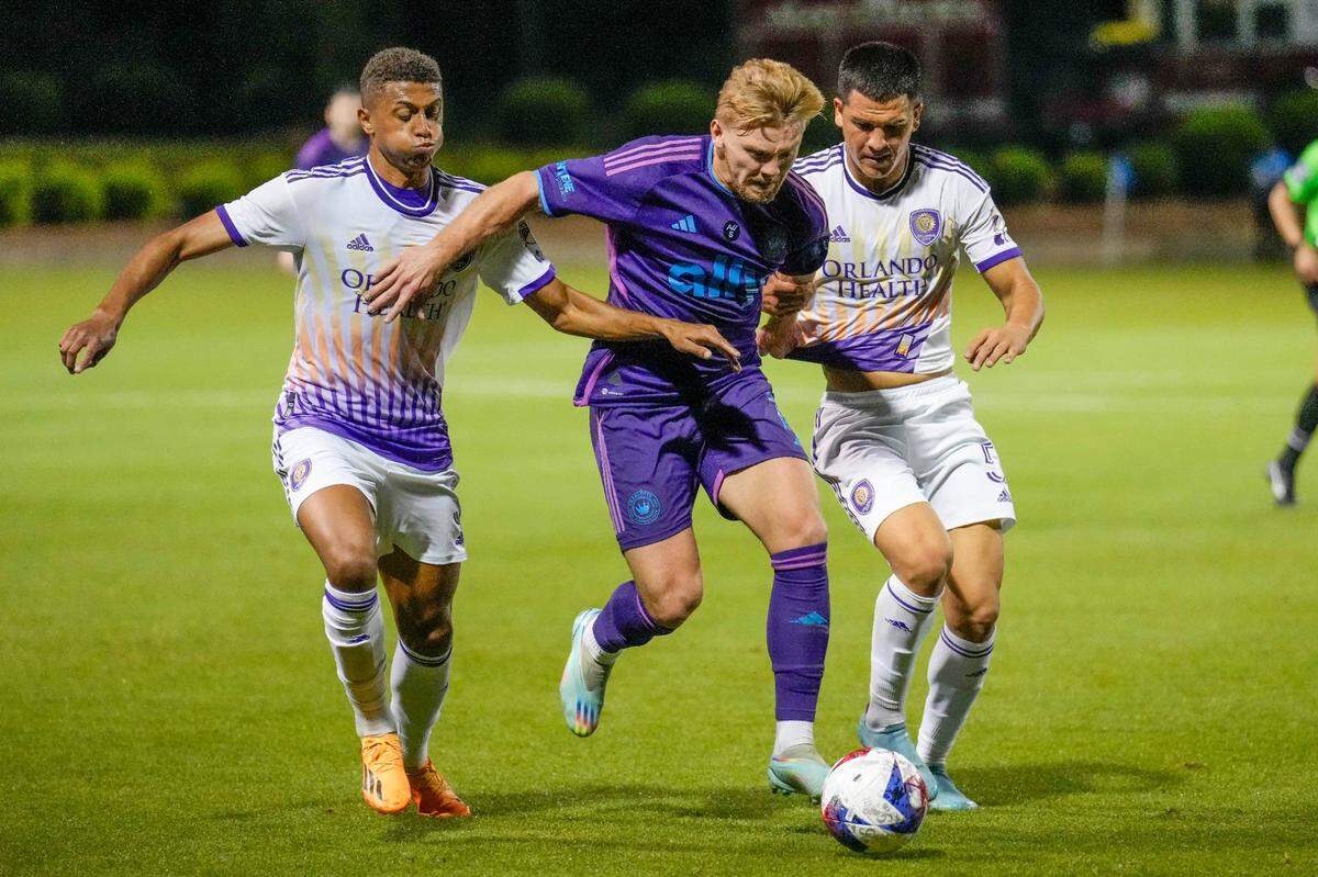 Charlotte FC midfielder Kamil Jozwiak (7) is double teamed by Orlando City midfielder Cesar Araujo (5) and defender Rafael Santos (3) during the second half at Mecklenburg County Sportsplex.