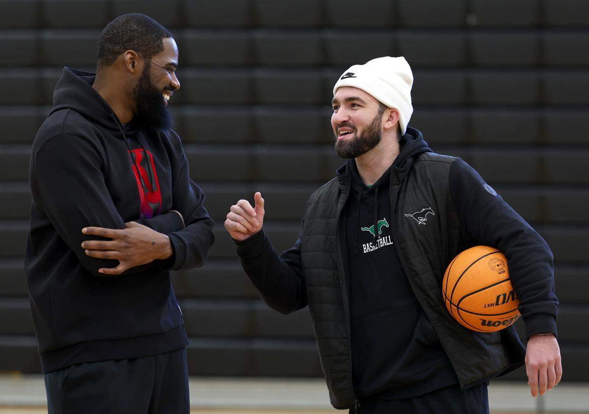 Former UNC great and NBA star Antawn Jamison, left and Myers Park head basketball coach Andrew Glover, right, joke with one another on Wednesday, January 15, 2025 at Myers Park High School. Antawn Jamison’s son, AJ Jamison, a senior at Myers Park is enjoying a really good senior season as the team is trying to win the league title.