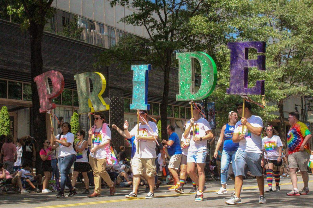 Paradegoers hold up letters spelling out “pride” during the 2023 Charlotte Pride Parade.