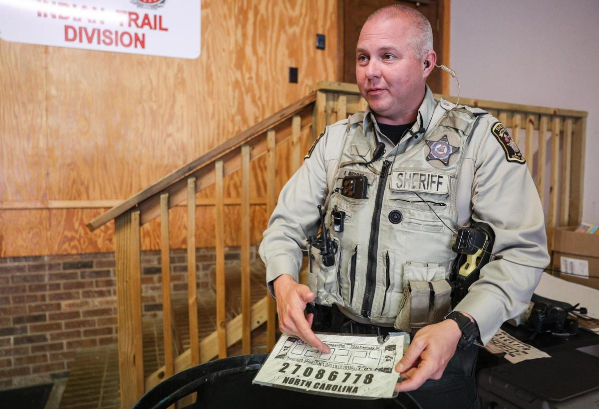 Deputy Jay Murray points to a date written over white-out as an obvious sign of a fake temporary license plate in Indian Trail on Friday.