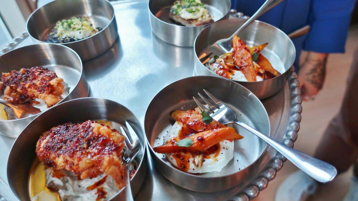 A sample of bites from Albertine’s that includes crispy pickled-brined South Carolina quail with aleppo pepper hot honey and cucumber labneh; roasted carrots with olio nuovo and nepitella; and crispy malawach with caviar and creme fraiche.