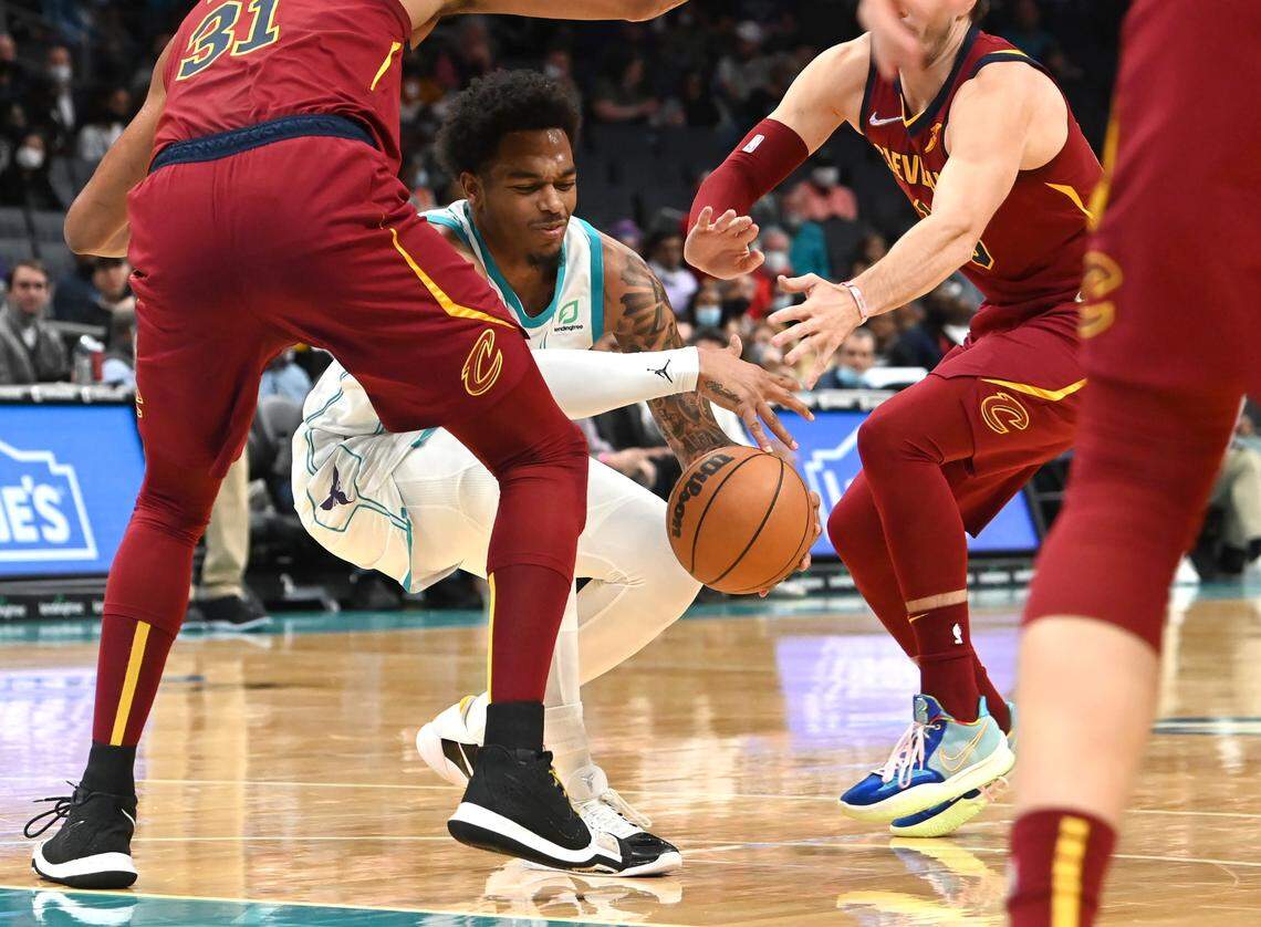 Charlotte Hornets forward PJ Washington, center, tries to regain control of a loose ball Monday. The Hornets committed 13 first-half turnovers, leading to 22 Cleveland points, in a 113-110 Cleveland win.