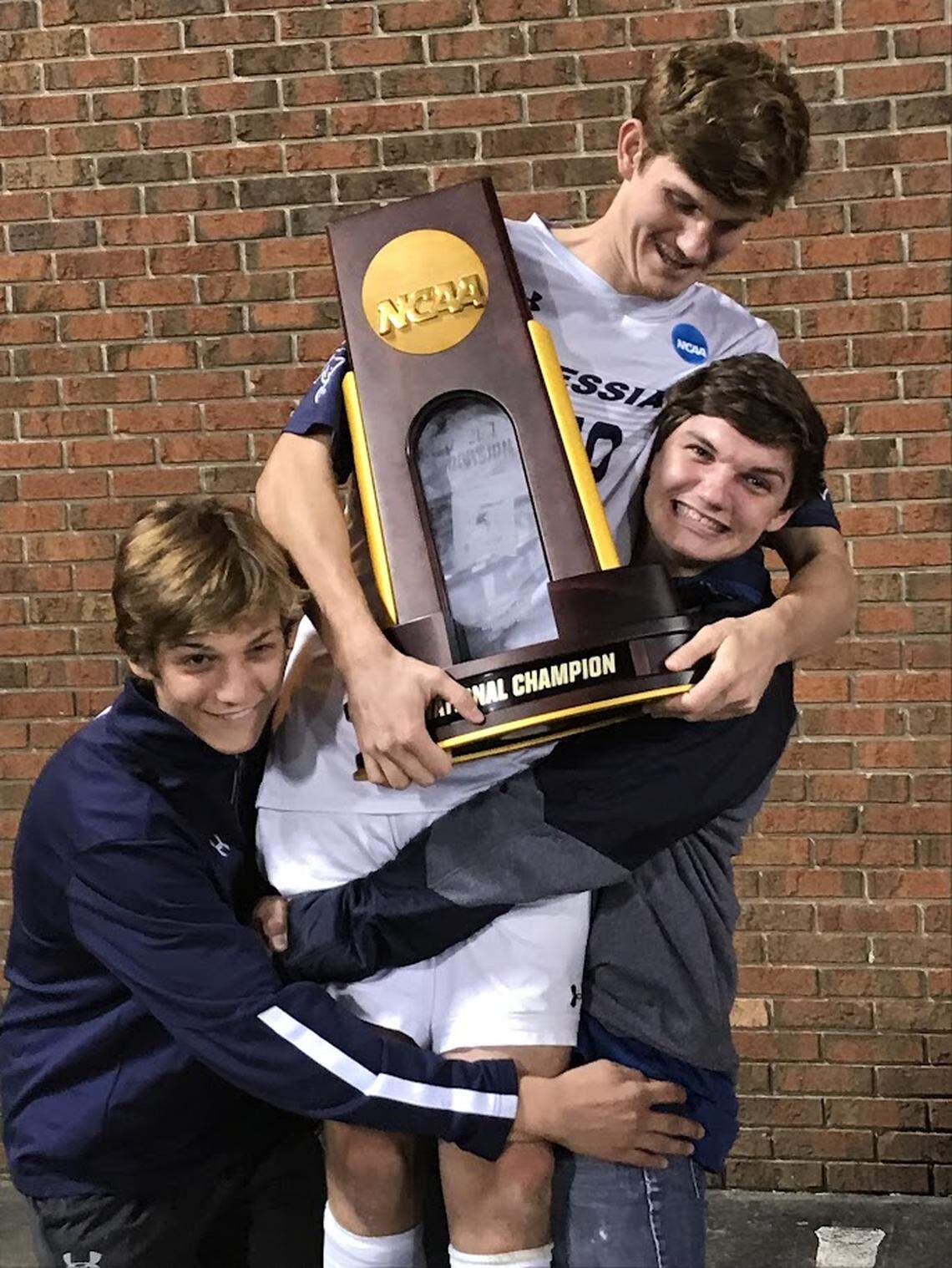 Josh Bender, center, celebrates his Division III national soccer title at Messiah University with brothers Ben, left, and Jacob.