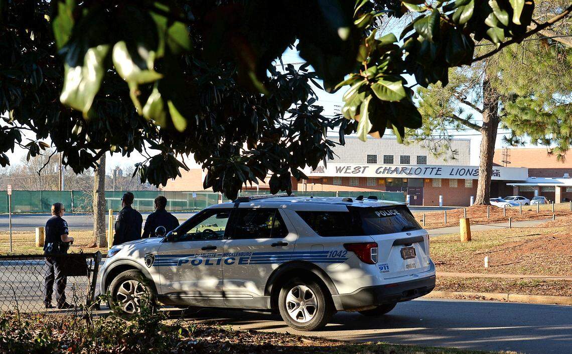 Charlotte-Mecklenburg police officers stand watch outside of West Charlotte High School along Senior Drive on Monday, December 13, 2021. Officials say a fight over a bookbag led to gunfire on the campus.