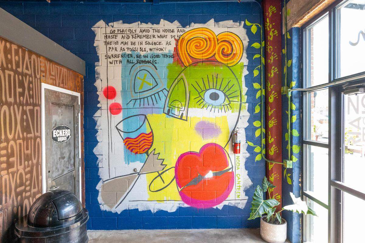Art by co-owner Joey Hewell covers the walls inside NoDa Company Store Canteen in Camp North End.