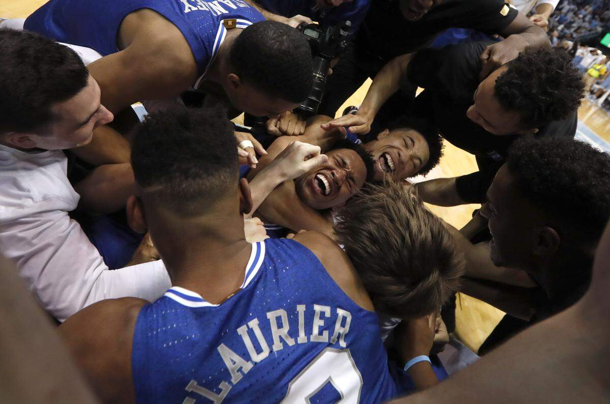 Duke’s Wendell Moore Jr. (0) is surrounded by teammates after Duke’s 98-96 overtime victory over UNC in February. Moore termed that moment the most memorable of his freshman season.