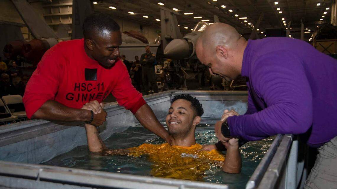 Baptism in an aircraft engine case for Charlotte area sailor on isolated Navy carrier