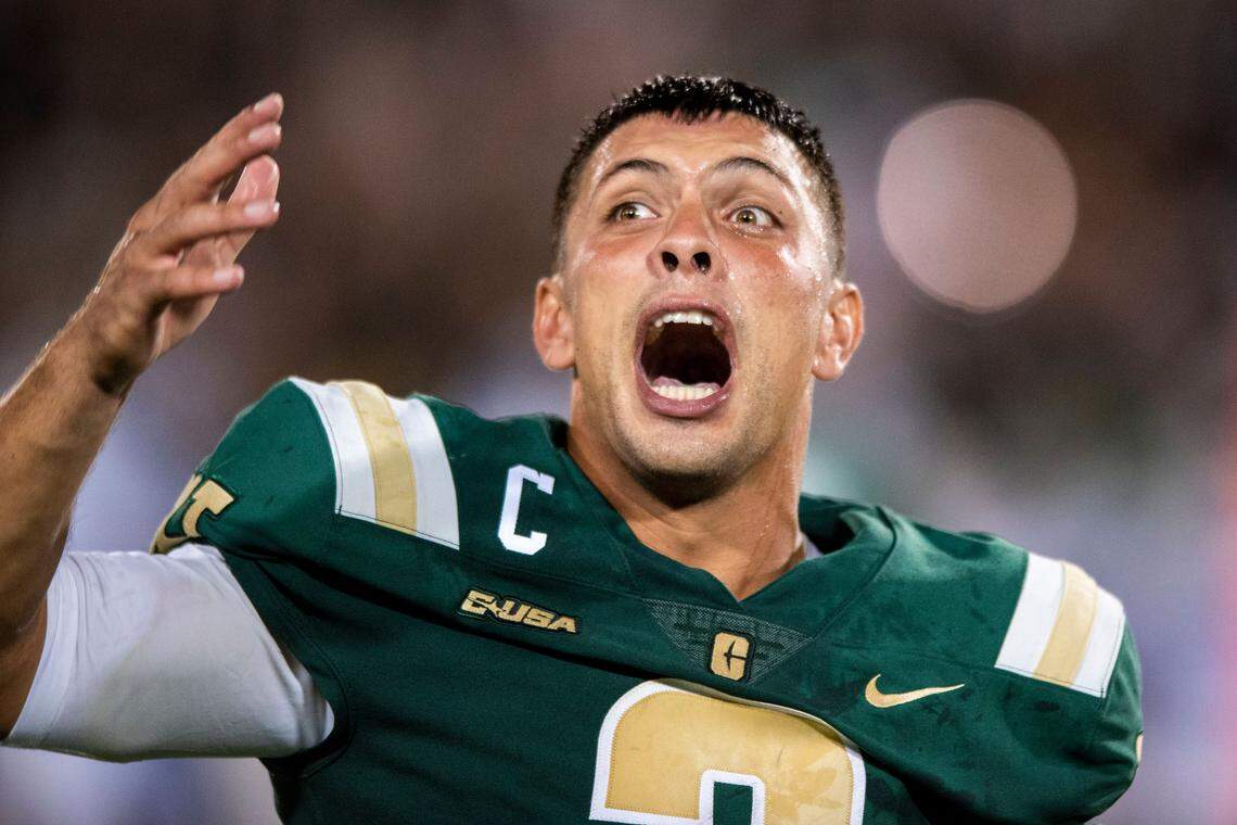 Charlotte 49ers quarterback Chris Reynolds sprays water from a bottle as he yells at the crowd to cheer for the team during its 31-28 win over Duke Friday night.