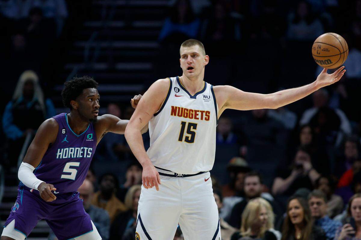Denver Nuggets center Nikola Jokic (15) takes in a pass as Charlotte Hornets center Mark Williams (5) defends during the first half of an NBA basketball game in Charlotte, N.C., Saturday, Feb. 11, 2023. (AP Photo/Nell Redmond)