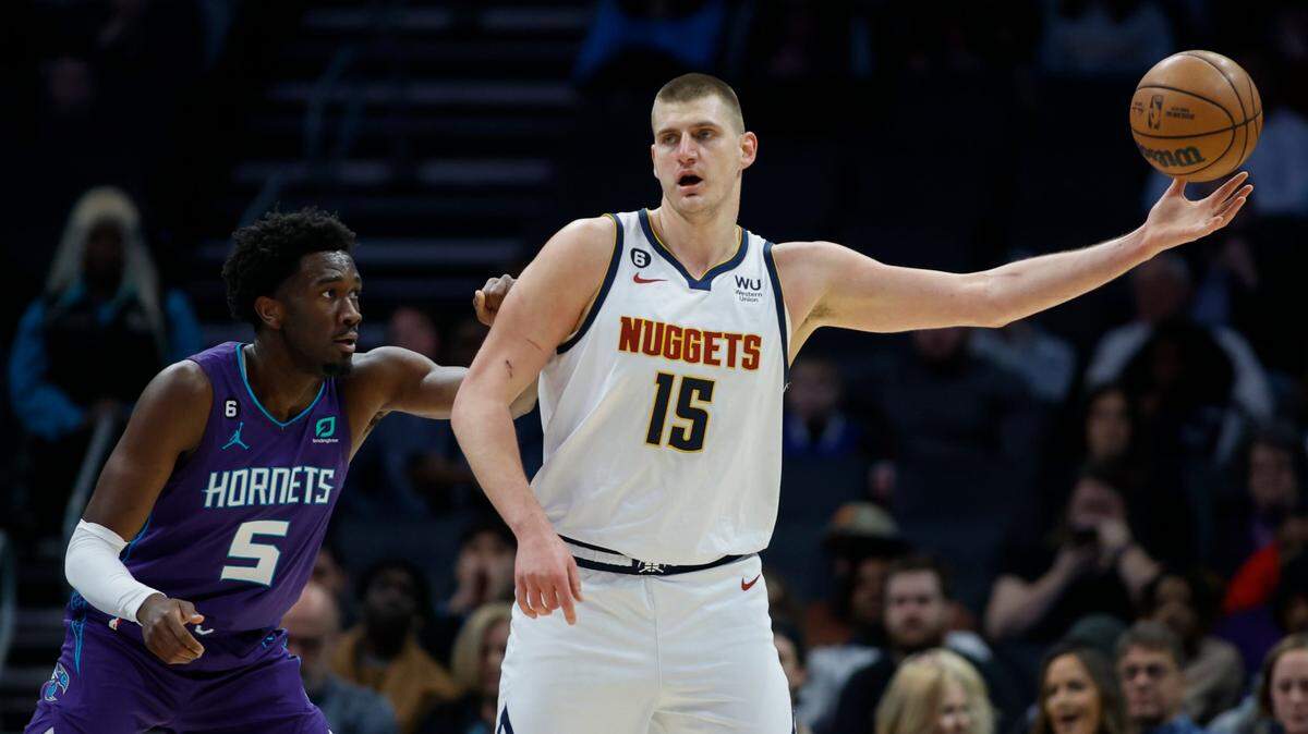Denver Nuggets center Nikola Jokic (15) takes in a pass as Charlotte Hornets center Mark Williams (5) defends during the first half of an NBA basketball game in Charlotte, N.C., Saturday, Feb. 11, 2023. (AP Photo/Nell Redmond)